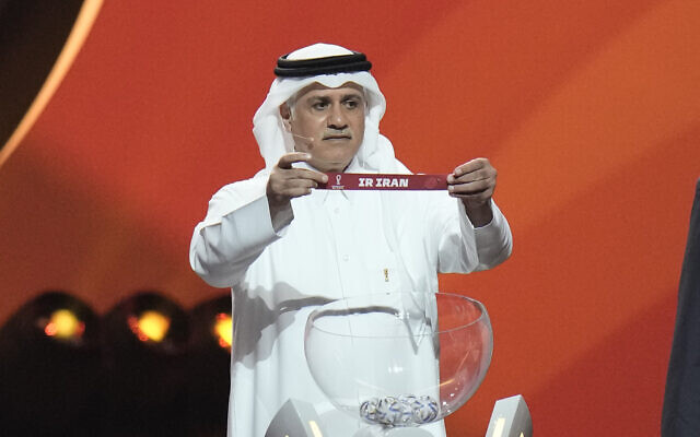 Former Qatari soccer international Adel Ahmed MalAllah holds up the name of Iran during the 2022 soccer World Cup draw at the Doha Exhibition and Convention Center in Doha, Qatar, Friday, April 1, 2022. (AP Photo/Hassan Ammar) Former Qatari soccer international Adel Ahmed MalAllah holds up the name of Iran during the 2022 soccer World Cup draw at the Doha Exhibition and Convention Center in Doha, Qatar, Friday, April 1, 2022. (AP Photo/Hassan Ammar)
