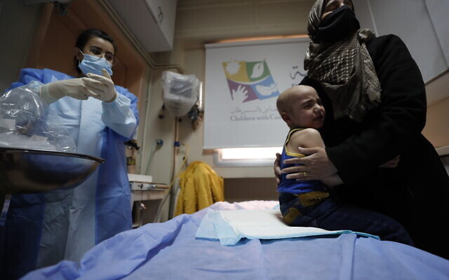 A woman holds her crying child at the cancer ward of the Children's Hospital in Damascus, Syria, on Monday, March 7, 2022. (AP Photo/Omar Sanadiki) A woman holds her crying child at the cancer ward of the Children's Hospital in Damascus, Syria, on Monday, March 7, 2022. (AP Photo/Omar Sanadiki)