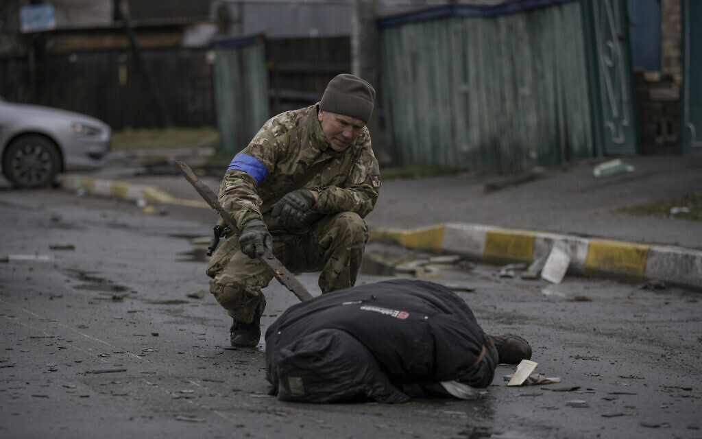 A Ukrainian serviceman checks the dead body of a civilian for booby traps in the formerly Russian-occupied Kyiv suburb of Bucha, Ukraine, April 2, 2022. (AP Photo/Vadim Ghirda) A Ukrainian serviceman checks the dead body of a civilian for booby traps in the formerly Russian-occupied Kyiv suburb of Bucha, Ukraine, April 2, 2022. (AP Photo/Vadim Ghirda)