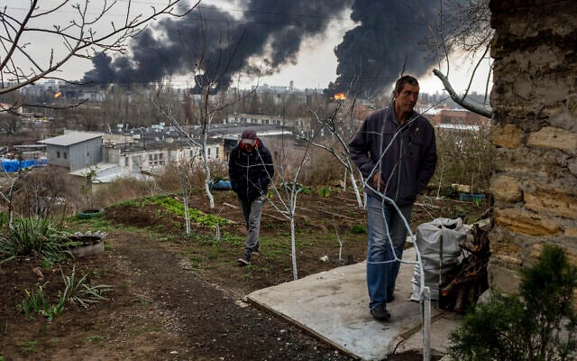 Men walk in a yard as smoke rises in the air in the background after shelling in Odessa, Ukraine, April 3, 2022. (AP Photo/Petros Giannakouris) Men walk in a yard as smoke rises in the air in the background after shelling in Odessa, Ukraine, April 3, 2022. (AP Photo/Petros Giannakouris)