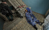 The lifeless body of a man lies in the staircase of a building in Bucha, Ukraine, Sunday, April 3, 2022. Associated Press journalists in Bucha, a small city northwest of Kyiv, saw the bodies of at least nine people in civilian clothes who appeared to have been killed at close range. At least two had their hands tied behind their backs. (AP Photo/Vadim Ghirda)