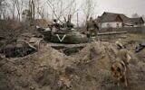 A Ukrainian serviceman walks on an abandoned Russian army tank in Andriivka, Ukraine, April 5, 2022 (AP Photo/Vadim Ghirda, File)