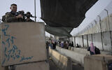 Israeli troops secure a checkpoint used by Palestinian to cross from the West Bank into Jerusalem, for the first Friday prayers in the Muslim holy month of Ramadan at the al-Aqsa mosque compound, at the Qalandiya checkpoint, west of Ramallah, on April 8, 2022. (AP Photo/Nasser Nasser)
