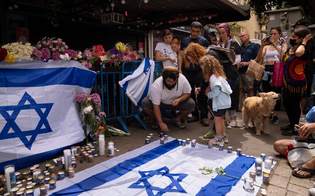 Israelis light candles at the site of a deadly terrorist attack, in Tel Aviv April 8, 2022 (AP Photo/Oded Balilty)