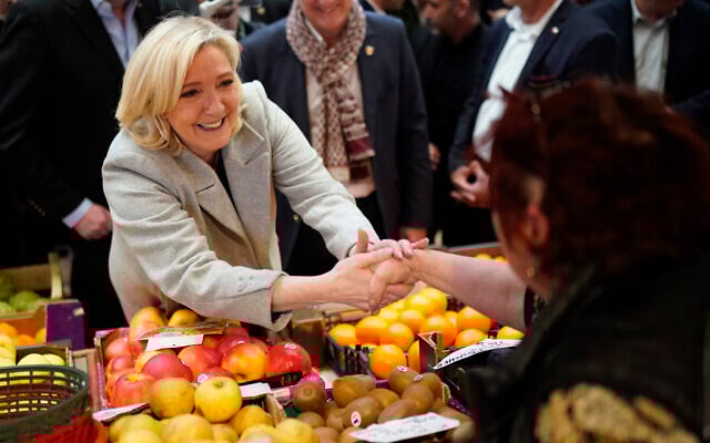 French far-right leader Marine Le Pen shakes hands to a fruits seller as she tours a food market in Narbonne, southern France, on April 8, 2022. (AP Photo/Joan Mateu Parra) French far-right leader Marine Le Pen shakes hands to a fruits seller as she tours a food market in Narbonne, southern France, on April 8, 2022. (AP Photo/Joan Mateu Parra)