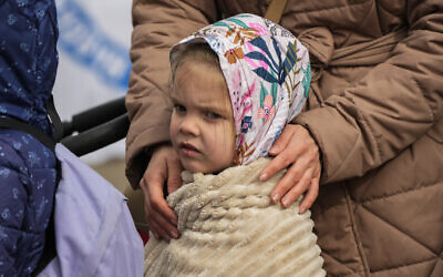 A refugee child waits in a line after fleeing the war from neighboring Ukraine at the border crossing in Medyka, southeastern Poland, on April 10, 2022. (AP Photo/Sergei Grits)