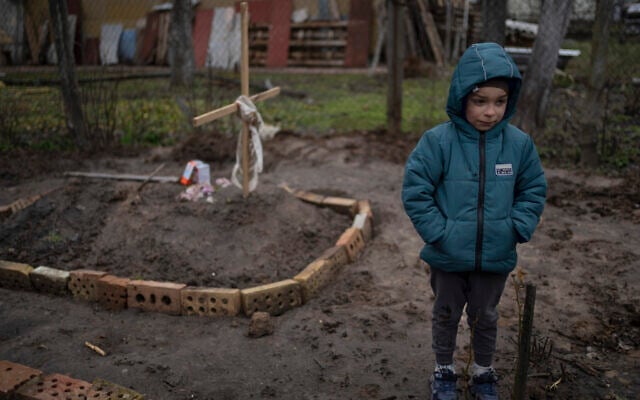 In the courtyard of their house, Vlad, 6, stands near the grave of his mother, who died, on the outskirts of Kyiv, Ukraine, on April 4, 2022. (AP Photo/Rodrigo Abd) In the courtyard of their house, Vlad, 6, stands near the grave of his mother, who died, on the outskirts of Kyiv, Ukraine, on April 4, 2022. (AP Photo/Rodrigo Abd)