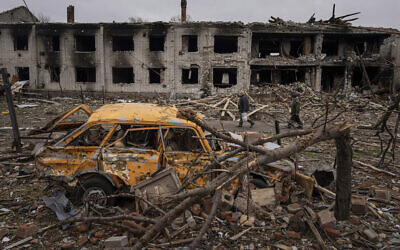 Men walk in a street destroyed by shelling in Chernihiv, Ukraine, on April 13, 2022. (AP Photo/Evgeniy Maloletka)