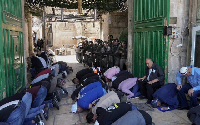 Israeli security forces stand guard as Palestinian men pray on the second Friday of the holy Islamic month of Ramadan in front of the Dome of the Rock shrine at the Temple Mount compound in Jerusalem's Old City, Friday, April 15, 2022. (AP/Mahmoud Illean) Israeli security forces stand guard as Palestinian men pray on the second Friday of the holy Islamic month of Ramadan in front of the Dome of the Rock shrine at the Temple Mount compound in Jerusalem's Old City, Friday, April 15, 2022. (AP/Mahmoud Illean)