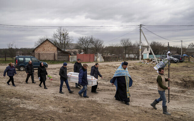 Liudmila Sumanchuk, third left, walks during the funeral ceremony for her granddaughter Veronika Kuts in Lgiv village, Chernihiv region, Ukraine, April 8, 2022. (AP Photo/Evgeniy Maloletka)