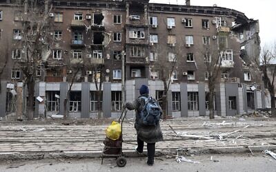 A local resident looks at a damaged during a heavy fighting apartment building near the Illich Iron & Steel Works Metallurgical Plant, the second largest metallurgical enterprise in Ukraine, in an area controlled by Russian-backed separatist forces in Mariupol, Ukraine, April 16, 2022. (AP Photo/Alexei Alexandrov)