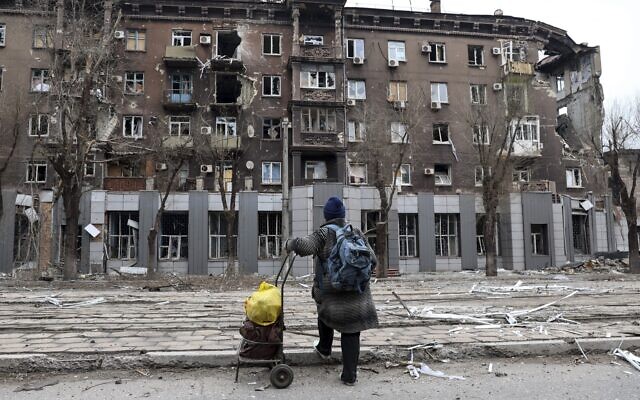 A local resident looks at a damaged during a heavy fighting apartment building near the Illich Iron & Steel Works Metallurgical Plant, the second largest metallurgical enterprise in Ukraine, in an area controlled by Russian-backed separatist forces in Mariupol, Ukraine, April 16, 2022. (AP Photo/Alexei Alexandrov)