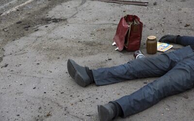 The body of a civilian lies on the ground at a bus stop not far from the Illich Iron & Steel Works Metallurgical Plant, the second largest metallurgical enterprise in Ukraine, in an area controlled by Russian-backed separatist forces in Mariupol, Ukraine, April 16, 2022. (AP Photo/Alexei Alexandrov)