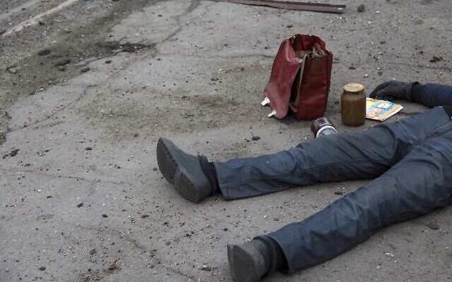 The body of a civilian lies on the ground at a bus stop not far from the Illich Iron & Steel Works Metallurgical Plant, the second largest metallurgical enterprise in Ukraine, in an area controlled by Russian-backed separatist forces in Mariupol, Ukraine, April 16, 2022. (AP Photo/Alexei Alexandrov)