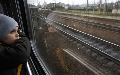 Sergei looks out of the window of a train minutes before arriving with his family in Lviv, from Kyiv, Ukraine, April 17, 2022. (AP Photo/Rodrigo Abd)