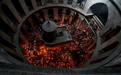 Christian pilgrims hold candles as they gather during the ceremony of the Holy Fire at Church of the Holy Sepulchre, where many Christians believe Jesus was crucified, buried, and rose from the dead, in the Old City of Jerusalem, April 23, 2022. (AP Photo/ Tsafrir Abayov)