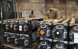 In this image provided by the US Air Force, Airmen and civilians from the 436th Aerial Port Squadron palletize ammunition, weapons and other equipment bound for Ukraine during a foreign military sales mission at Dover Air Force Base, Delaware, on January 21, 2022. (Mauricio Campino/US Air Force via AP)