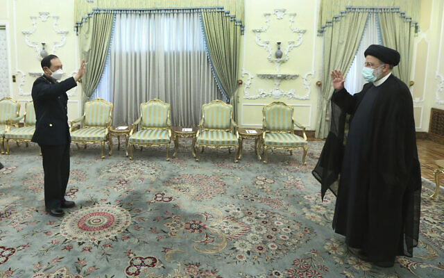 In this photo released by the official website of the office of the Iranian Presidency, President Ebrahim Raisi, right, and China's minister of national defense Gen. Wei Fenghe greet at the start of their meeting at the presidency office in Tehran, Iran, April 27, 2022. (Iranian Presidency Office via AP)