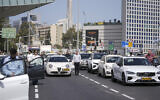 Israelis stand still next to their cars on a freeway as a two-minute siren sounds in memory of victims of the Holocaust in Tel Aviv, Israel, April 28, 2022 (AP Photo/Ariel Schalit)