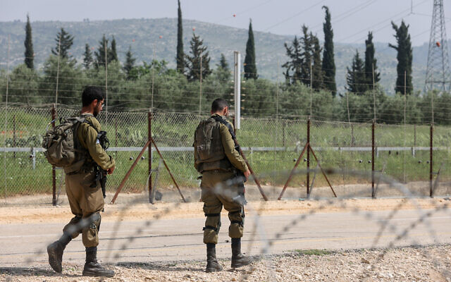 File: Israeli soldiers stand guard near a hole in the security fence, as Palestinians try to cross into Israel, near Mevo Horon, April 10, 2022. (Flash90) File: Israeli soldiers stand guard near a hole in the security fence, as Palestinians try to cross into Israel, near Mevo Horon, April 10, 2022. (Flash90)