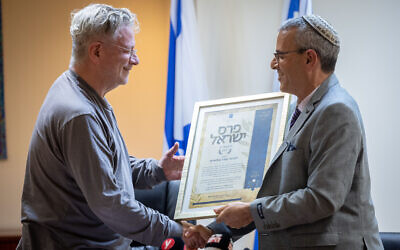 Weizmann Institute math and computer science professor Oded Goldreich (left) receives the Israel Prize at a ceremony at the Education Ministry in Jerusalem, on April 11, 2022. (Yonatan Sindel/Flash90)