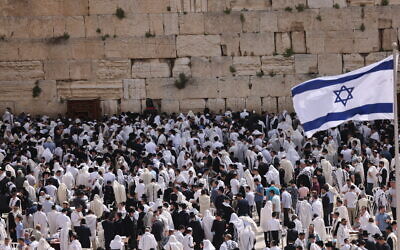 Jewish worshippers cover themselves with prayer shawls as they pray in front of the Western Wall, Judaism's holiest prayer site, in Jerusalem's Old City, April 18, 2022. (Yonatan Sindel/Flash90)