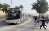Palestinians throw rocks at an Israeli bus outside Jerusalem's Old City on April 17, 2022. (Screen capture: Twitter)