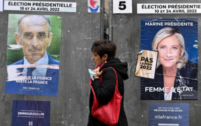 A pedestrian walks past campaign posters for French presidential candidates Eric Zemmour, left, and Marine Le Pen ahead of the first round of the French presidential election in Paris, on April 7, 2022. (Emmanuel Dunand/AFP/Getty Images via JTA)