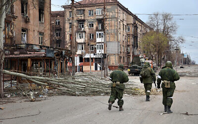 Pro-Russia troops from the Donetsk People's Republic militia walk past damaged apartment buildings near the Illich Iron & Steel Works Metallurgical Plant in an area controlled by Russian-backed separatist forces in Mariupol, Ukraine, April 16, 2022. (AP Photo/Alexei Alexandrov) Pro-Russia troops from the Donetsk People's Republic militia walk past damaged apartment buildings near the Illich Iron & Steel Works Metallurgical Plant in an area controlled by Russian-backed separatist forces in Mariupol, Ukraine, April 16, 2022. (AP Photo/Alexei Alexandrov)