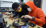 Ukrainian activists work on a drone in western Lviv, on April 1, 2022. (Aleksey Filippov/AFP)