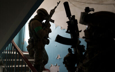 Security Service of Ukraine (SBU) servicemen enter a building during an operation to arrest suspected Russian collaborators in Kharkiv, Ukraine, April 14, 2022. (AP Photo/Felipe Dana)
