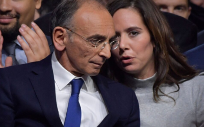 French far-right media pundit and 2022 presidential candidate Eric Zemmour, left, listens to his advisor Sarah Knafo after presenting the name of his new party "Reconquete!" at the end of a campaign rally in Villepinte, near Paris, December 5, 2021. (Julien de Rosa/AFP /Getty Images via JTA)