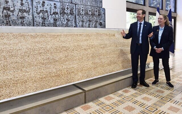 President Herzog and First Lady Michal Herzog are presented with Israel's biggest matzah at the President's House in Jerusalem, April 10, 2022. (Haim Zach/GPO) President Herzog and First Lady Michal Herzog are presented with Israel's biggest matzah at the President's House in Jerusalem, April 10, 2022. (Haim Zach/GPO)