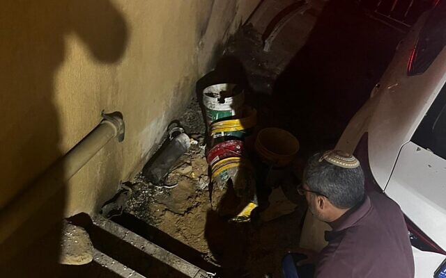 Sderot Mayor Alon Davidi is seen next to a section of a rocket fired from the Gaza Strip that landed near a home in the southern city, April 20, 2022. (Courtesy)