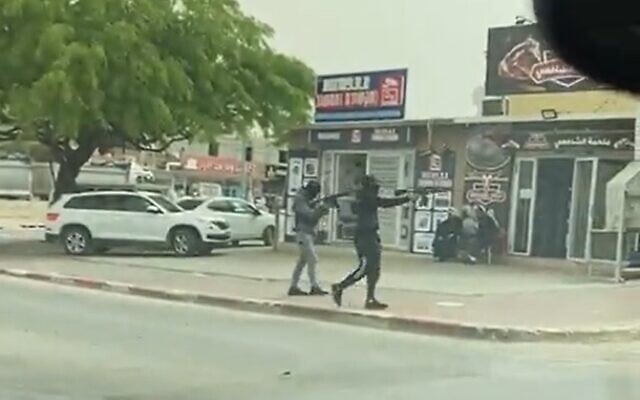 Screen grab of a video apparently showing gunmen opening fire toward a store in Rahat, April 24, 2022 (Screen grab/Kan) Screen grab of a video apparently showing gunmen opening fire toward a store in Rahat, April 24, 2022 (Screen grab/Kan)