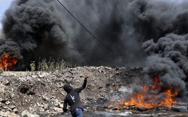 A Palestinian man hurls rocks at Israeli soldiers amid clashes in the town of Kafr Qaddum in the West Bank, on May 6, 2022. (JAAFAR ASHTIYEH / AFP) A Palestinian man hurls rocks at Israeli soldiers amid clashes in the town of Kafr Qaddum in the West Bank, on May 6, 2022. (JAAFAR ASHTIYEH / AFP)