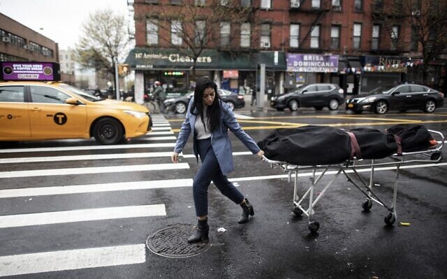 A funeral service manager transports a body to the funeral home in the Harlem neighborhood of New York City, April 24, 2020. (Johannes EISELE / AFP) A funeral service manager transports a body to the funeral home in the Harlem neighborhood of New York City, April 24, 2020. (Johannes EISELE / AFP)