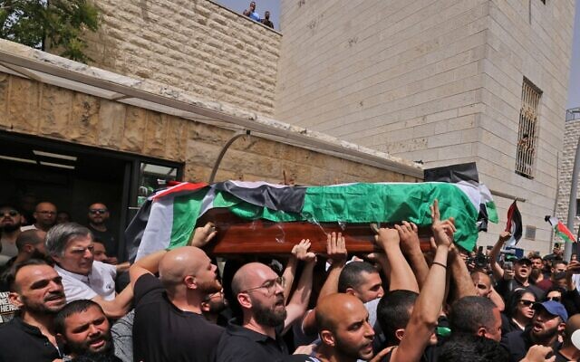 Palestinian mourners carry the casket of Al Jazeera journalist Shireen Abu Akleh out of a hospital, before being transported to a church and then her resting place, in Jerusalem, on May 13, 2022 (AHMAD GHARABLI / AFP) Palestinian mourners carry the casket of Al Jazeera journalist Shireen Abu Akleh out of a hospital, before being transported to a church and then her resting place, in Jerusalem, on May 13, 2022 (AHMAD GHARABLI / AFP)