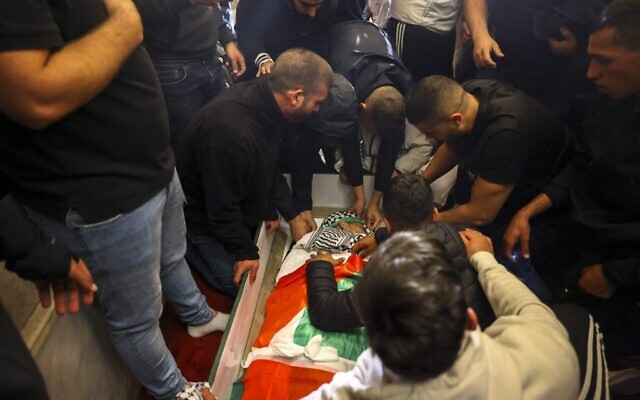Palestinian mourners surround the body of Walid al-Sharif who died of wounds suffered during clashes with Israeli police at Jerusalem's Temple Mount, on May 16, 2022. ( AHMAD GHARABLI / AFP) Palestinian mourners surround the body of Walid al-Sharif who died of wounds suffered during clashes with Israeli police at Jerusalem's Temple Mount, on May 16, 2022. ( AHMAD GHARABLI / AFP)