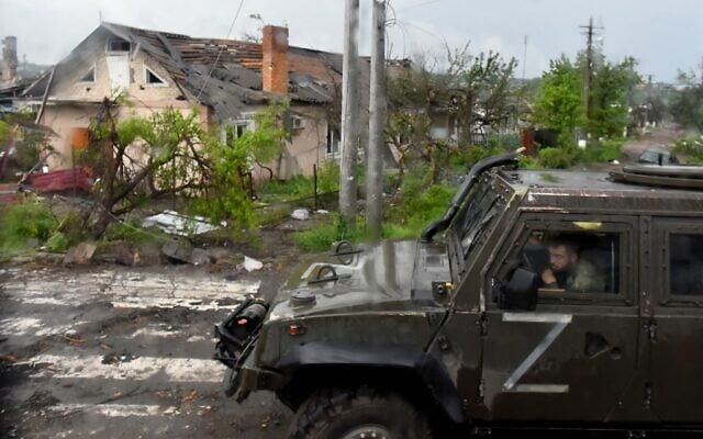A Russian military vehicle painted with the letter Z drives past destroyed houses in Ukraine's port city of Mariupol on May 18, 2022. (Olga MALTSEVA / AFP) A Russian military vehicle painted with the letter Z drives past destroyed houses in Ukraine's port city of Mariupol on May 18, 2022. (Olga MALTSEVA / AFP)