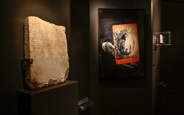 A stele of a Jewish slave, dated circa 300-250 BCE (L), is displayed in the exhibition "Stone Paths - Stories set in Stone: Jewish Inscriptions in Greece," at the Jewish Museum of Greece, in Athens, May 17, 2022. (Louisa Gouliamaki/AFP) A stele of a Jewish slave, dated circa 300-250 BCE (L), is displayed in the exhibition "Stone Paths - Stories set in Stone: Jewish Inscriptions in Greece," at the Jewish Museum of Greece, in Athens, May 17, 2022. (Louisa Gouliamaki/AFP)