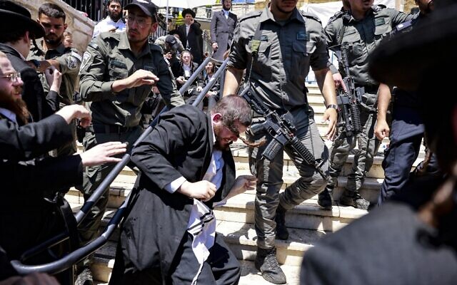 Ultra-Orthodox Jews scuffle with the police as they try to enter the gravesite of Rabbi Shimon Bar Yochai at Mount Meron, during the Lag B'Omer holiday that commemorates the 2nd-century Jewish scholar's death, May 19, 2022. (Menahem KAHANA / AFP)