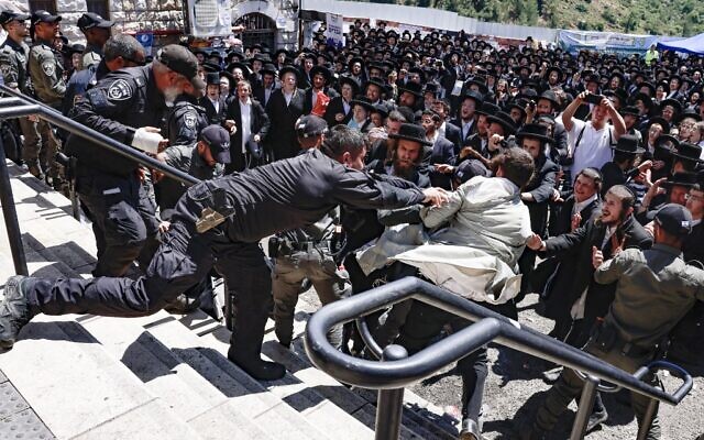 Ultra-Orthodox Jews scuffle with the police as they try to enter the gravesite of Rabbi Shimon Bar Yochai at Mount Meron, during the Lag B'Omer holiday that commemorates the 2nd-century Jewish scholar's death, May 19, 2022. (Menahem KAHANA / AFP)