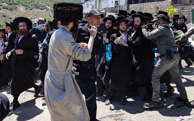 Ultra-Orthodox Jews scuffle with the police as they try to enter the gravesite of Rabbi Shimon Bar Yochai at Mount Meron, during the Lag B'Omer holiday that commemorates the 2nd-century Jewish scholar's death, May 19, 2022. (Menahem KAHANA / AFP)