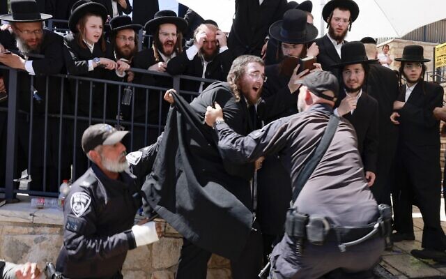 Ultra-Orthodox Jews scuffle with the police as they try to enter the gravesite of Rabbi Shimon Bar Yochai at Mount Meron, during the Lag B'Omer holiday that commemorates the 2nd-century Jewish scholar's death, May 19, 2022. (Menahem KAHANA / AFP)