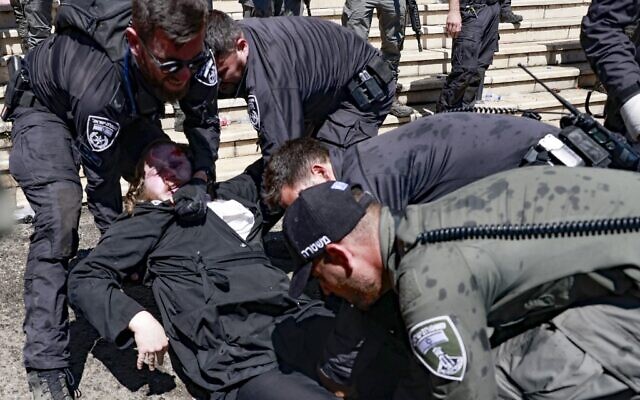An ultra-Orthodox man lies on the ground during scuffles with the police at the gravesite of Rabbi Shimon Bar Yochai at Mount Meron, during the Lag B'Omer holiday that commemorates the 2nd-century Jewish scholar's death, May 19, 2022. (Menahem KAHANA / AFP)