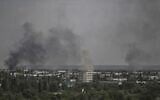 Smoke and dirt rise from the city of Severodonetsk, during shelling in the eastern Ukrainian region of Donbas, May 26, 2022, (Aris Messinis/AFP)