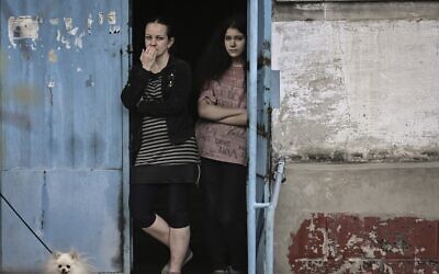 Women stand at the door of their apartment building in the city of Lysychansk, a city without electricity and water, in the eastern Ukrainian region of Donbas, on May 26, 2022. (ARIS MESSINIS / AFP)