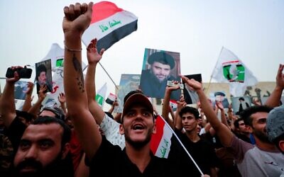 Supporters of Iraqi Shiite cleric Muqtada al-Sadr gather in Baghdad's Tahrir Square on May 26, 2022, to celebrate the passing of a bill that criminalizes normalization of ties with Israel. (Ahmad Al-Rubaye/AFP)