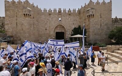 Israelis wave the national flag at the Damascus Gate to the Old City Jerusalem's as they mark Jerusalem Day, on May 29, 2022. - (AHMAD GHARABLI / AFP)